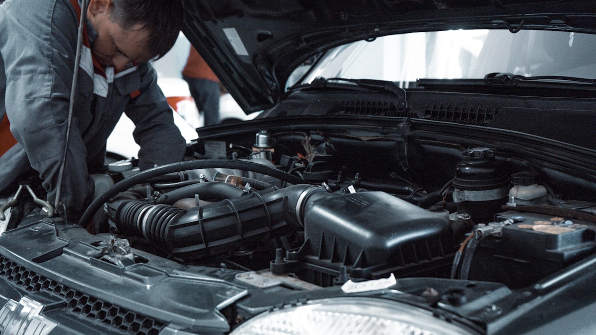 Mecanic profesionist în uniformă verificând motorul unei mașini în service-ul SMG Auto Service